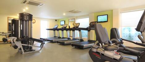 A gym with treadmills, elliptical machines, and a weight machine.