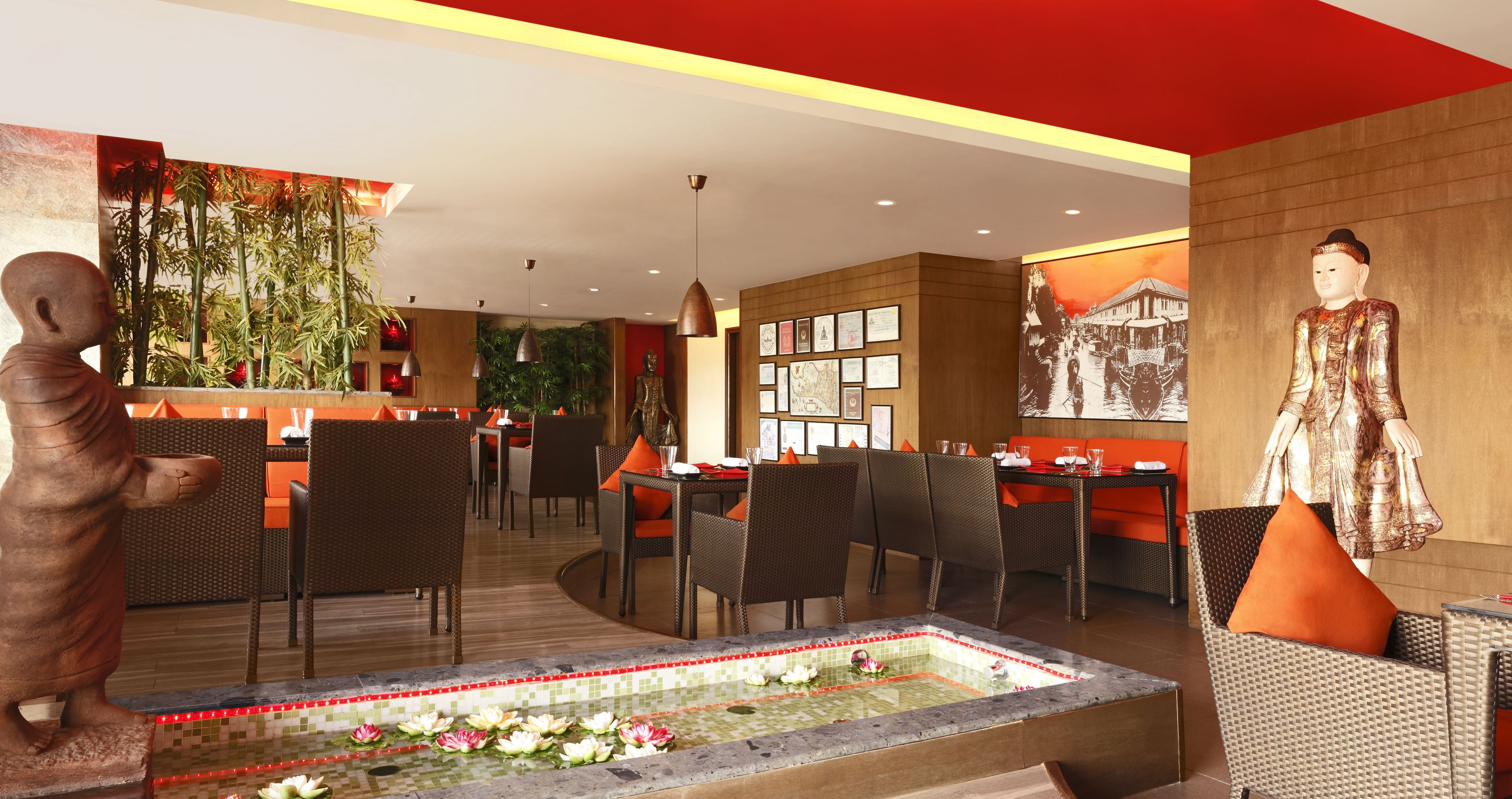 A hotel lobby with wicker furniture, a decorative fountain, and a statue.
