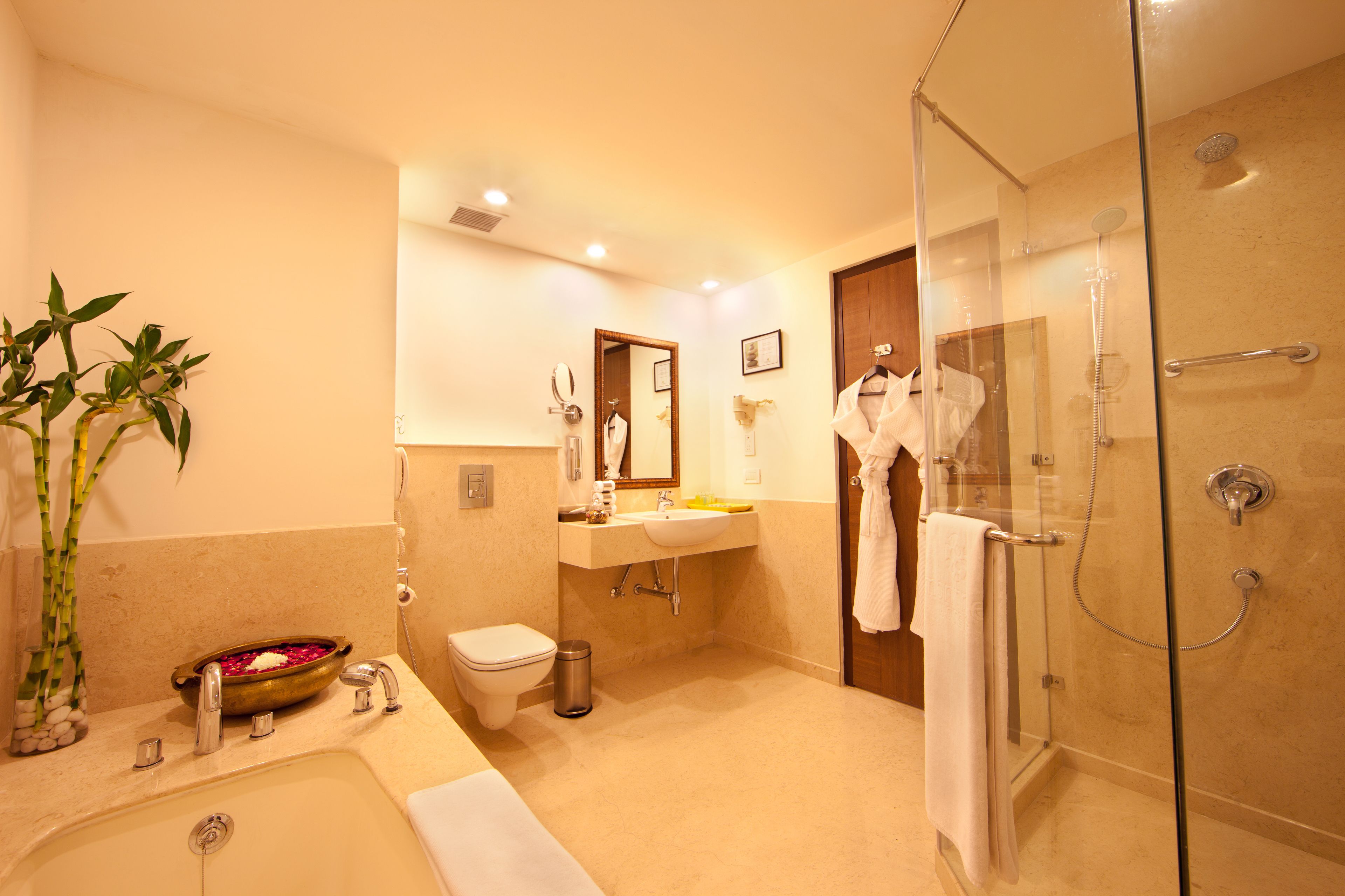 A modern bathroom with a bathtub, sink, toilet, and glass-enclosed shower.
