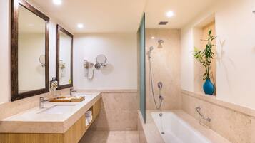Un baño moderno con un espejo grande, dos lavamanos, una bañera y una ducha.