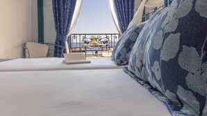 Ein Hotelzimmer mit Bett, einem Tisch mit Ananas und Meerblick vom Balkon.
