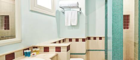 A bathroom with a bathtub, toilet, and shower area.