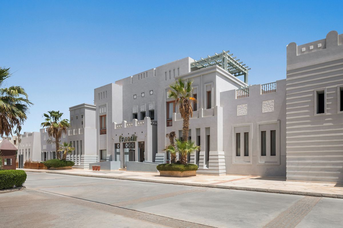 A modern building with a flat facade, large windows, and a gated entrance.