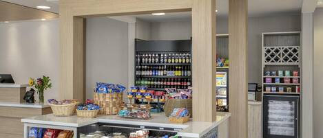 A modern retail area with a variety of products including snacks, beverages, and packaged goods.