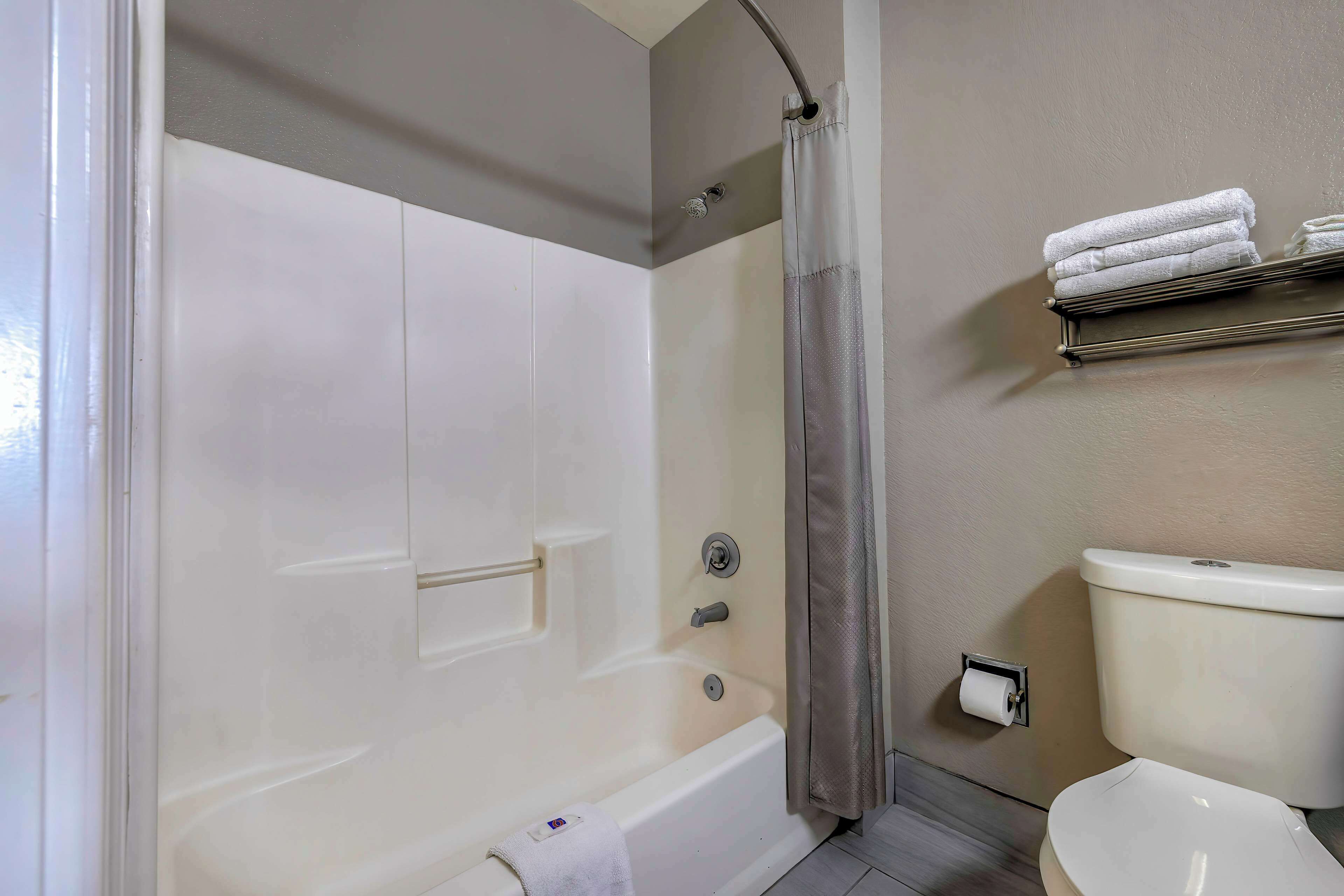 Ein Badezimmer mit Badewanne, Toilette und Handtuchhalter.