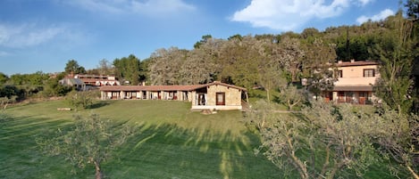 A large estate with multiple buildings, expansive grassy lawns, and mature trees.
