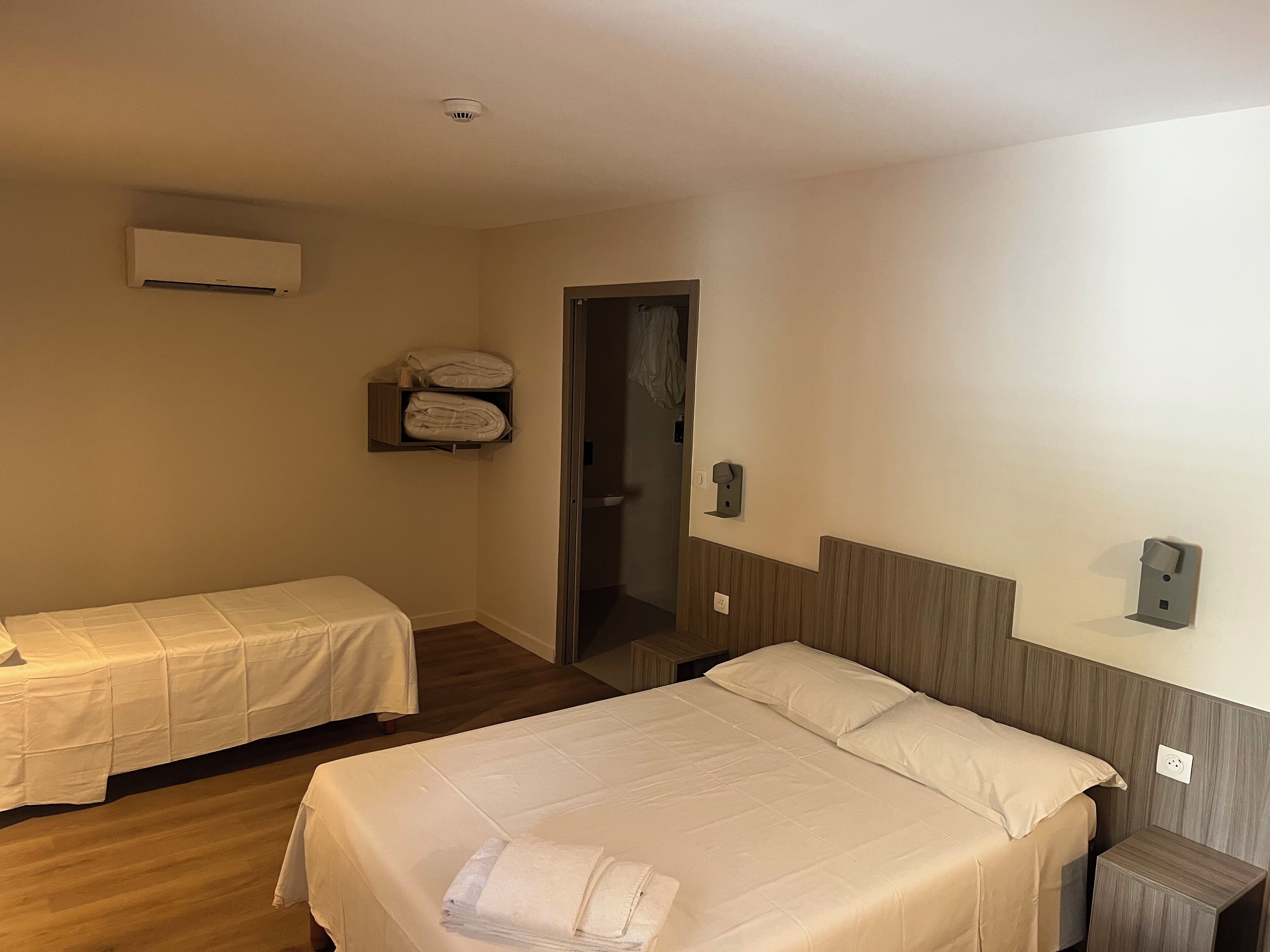 Driepersoonskamer | Bedden met traagschuimmatrassen, individueel gemeubileerd, een bureau