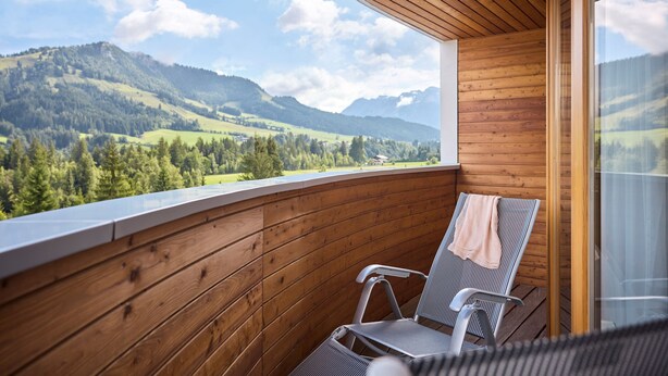 A wooden balcony with two chairs and a view of a mountainous landscape. - ROBINSON FIEBERBRUNN - Adults only (Fieberbrunn)