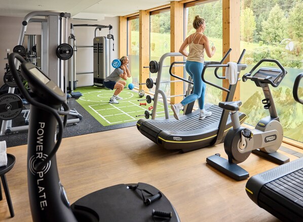 A gym with cardio machines, weightlifting equipment, and a green mat area. - ROBINSON FIEBERBRUNN - Adults only (Fieberbrunn)