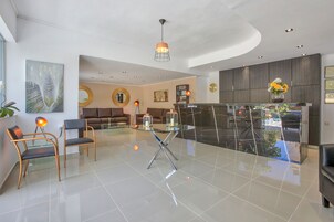 Un espacio habitable amplio con una mesa de centro de vidrio, muebles modernos y vistas a la calle.