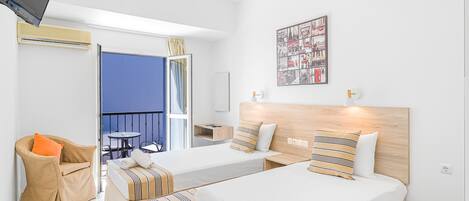 A hotel room with two beds, a sofa, a TV, a balcony, and a wall art piece.