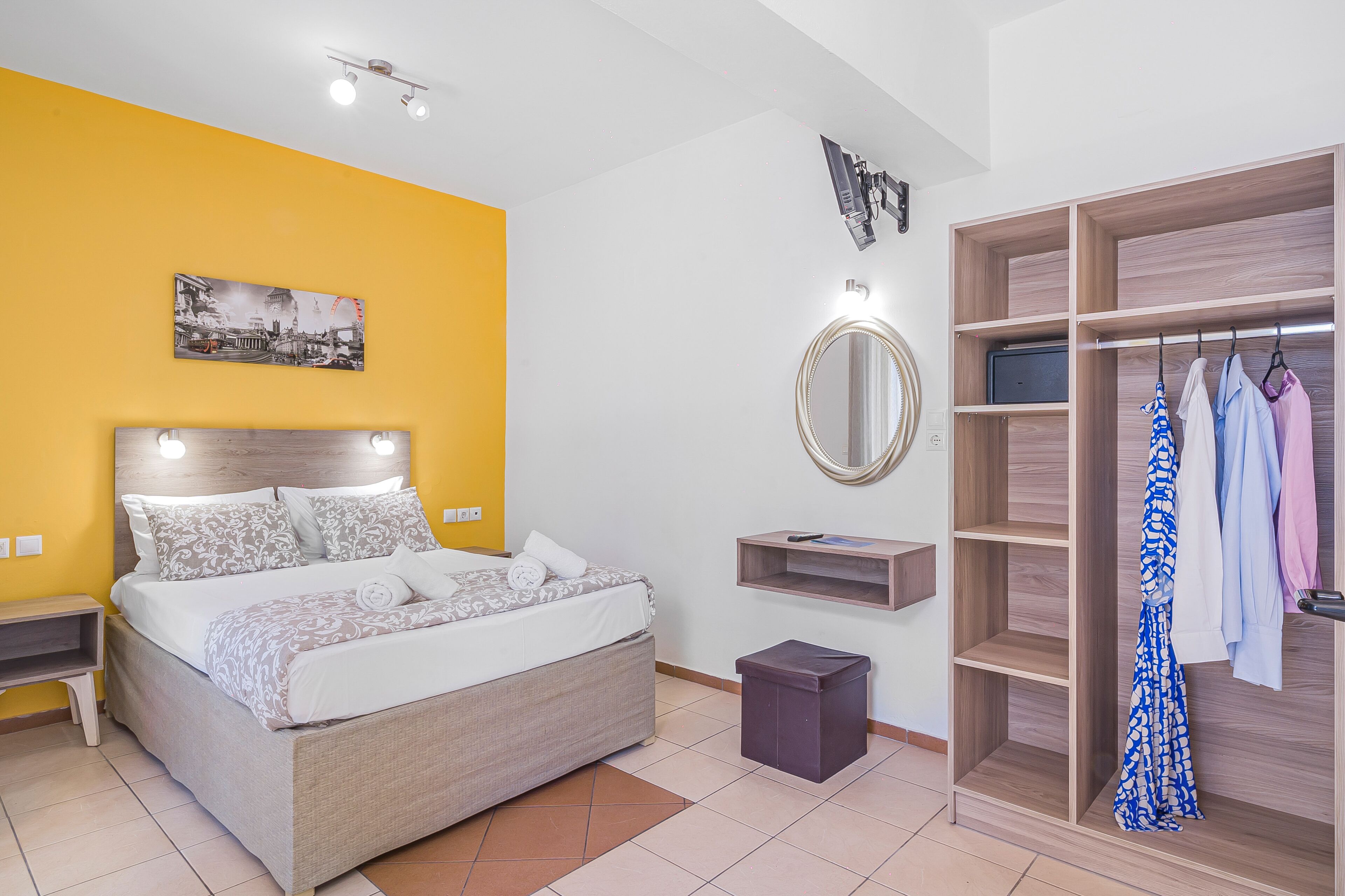 Un dormitorio con cama, mesita de noche, espejo, armario y un cuadro en la pared.