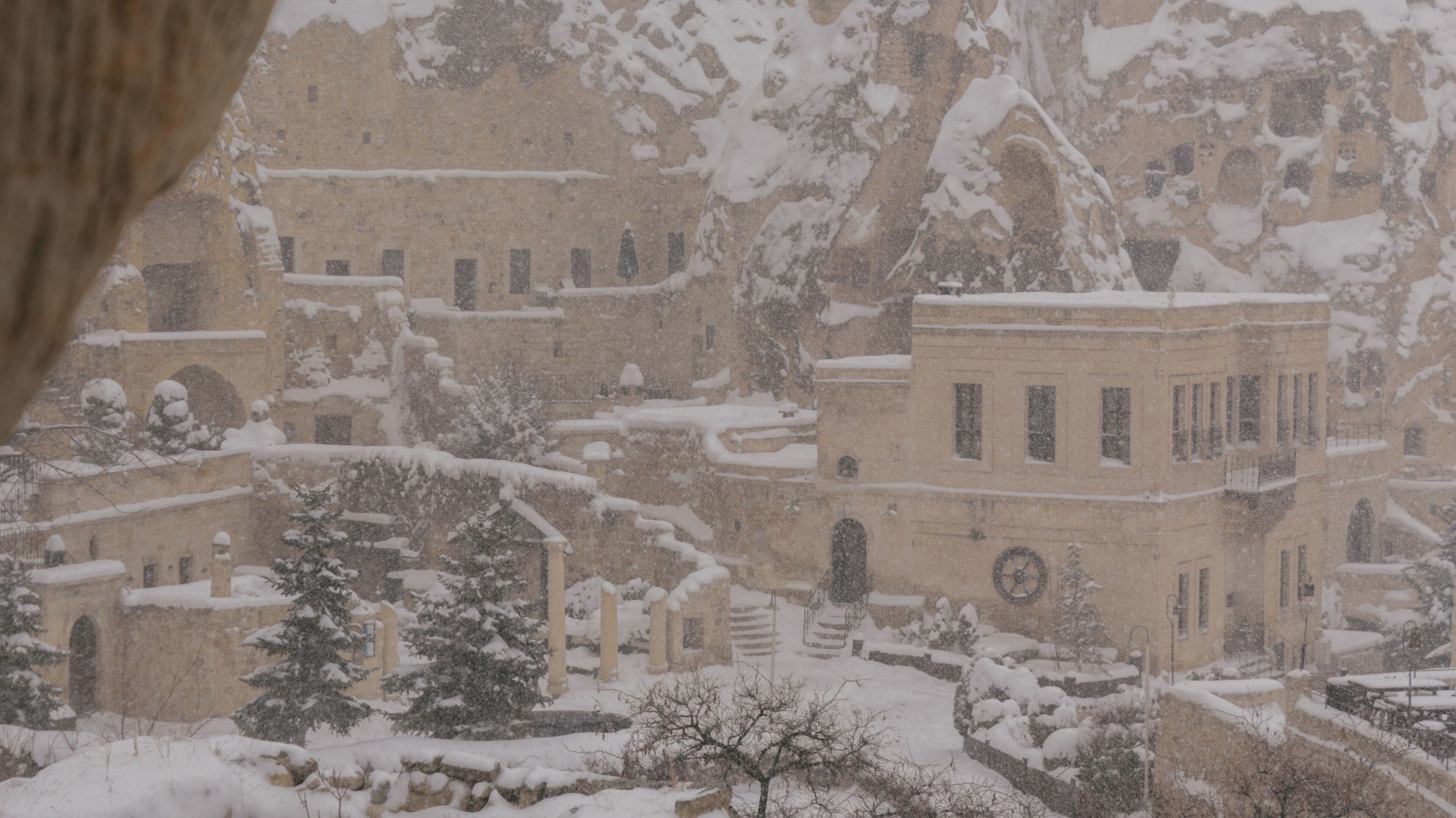 A snowy landscape with buildings and trees.