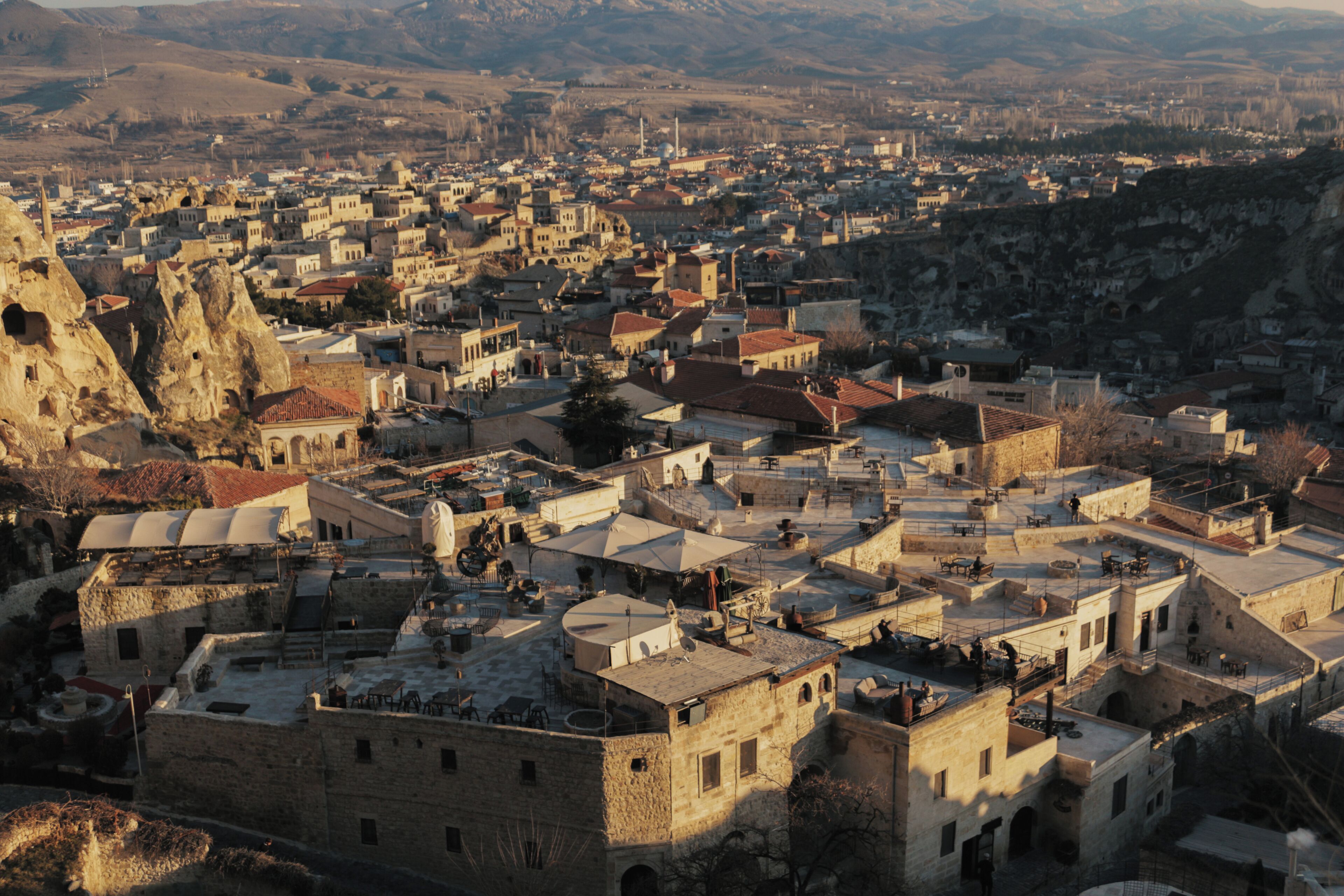Un pueblo histórico con edificios de piedra, calles estrechas y una formación rocosa destacada.