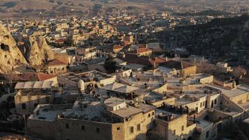 Un pueblo histórico con edificios de piedra, calles estrechas y una formación rocosa destacada.