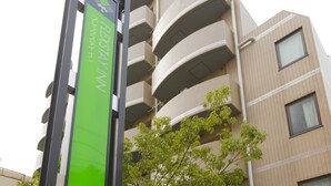 A multi-story building with a green sign that reads "FLEKSITY WIN". - Flexstay Inn Sugamo (Tokyo)