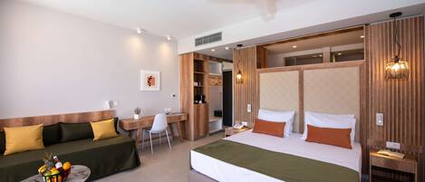 Una habitación de hotel con cama, sofá, escritorio y una silla.