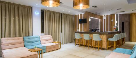 A modern living room with a sofa, a coffee table, and a bar area with stools.