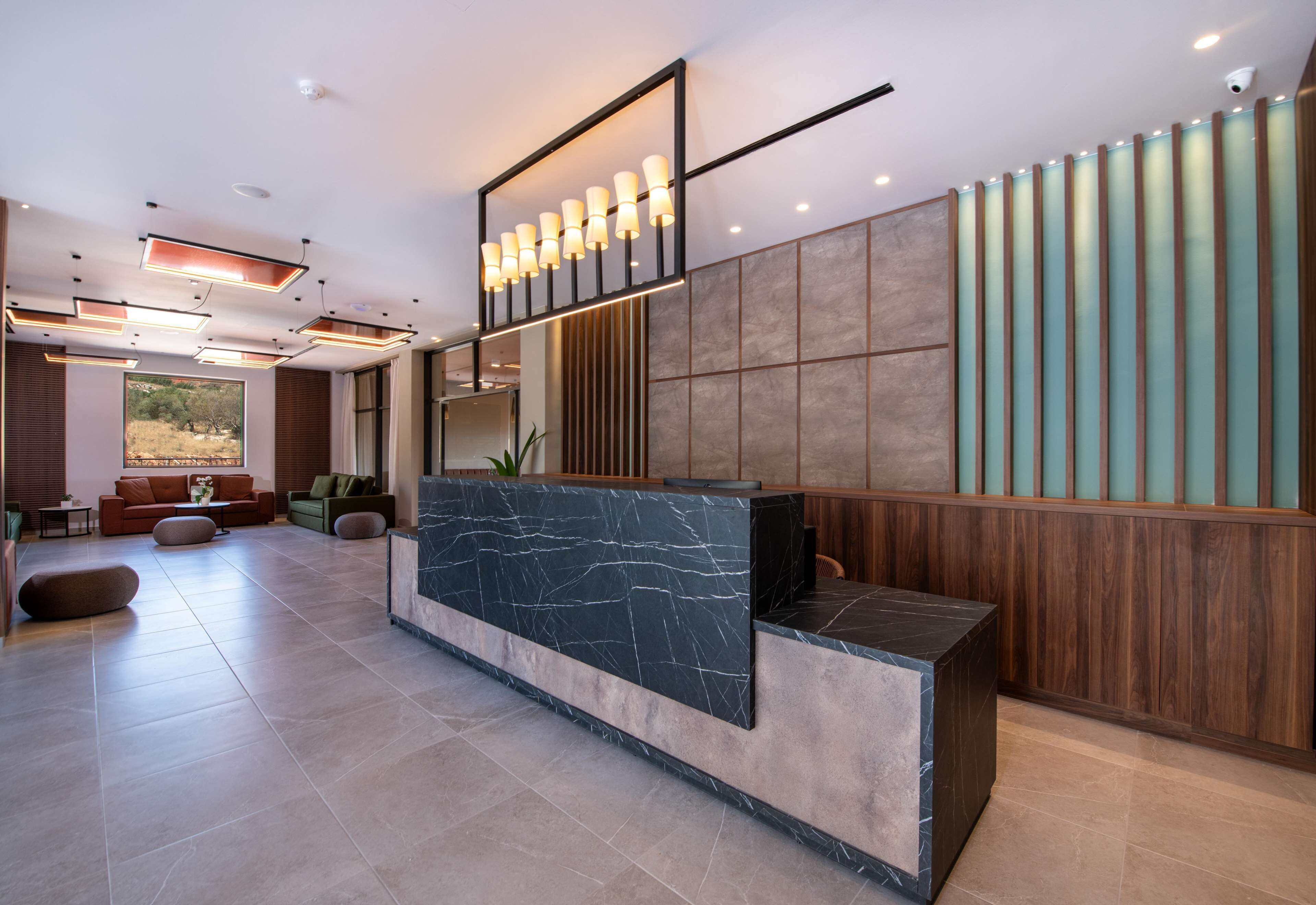 A modern reception area with a marble counter, wooden paneling, and recessed lighting.