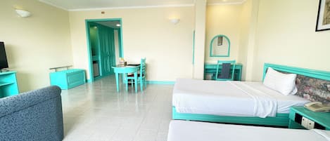 Una habitación de hotel con dos camas, un escritorio, una silla y un televisor.