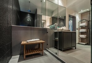 A modern bathroom with a glass shower enclosure, a wooden vanity, and a towel rack. - Hyatt Herald Square New York (New York)
