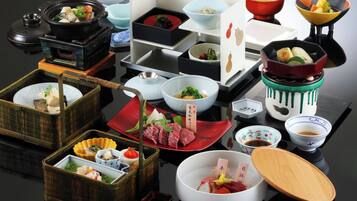 Diversos pratos e tigelas dispostos sobre uma mesa, incluindo um pote quente, sushi e acompanhamentos variados.