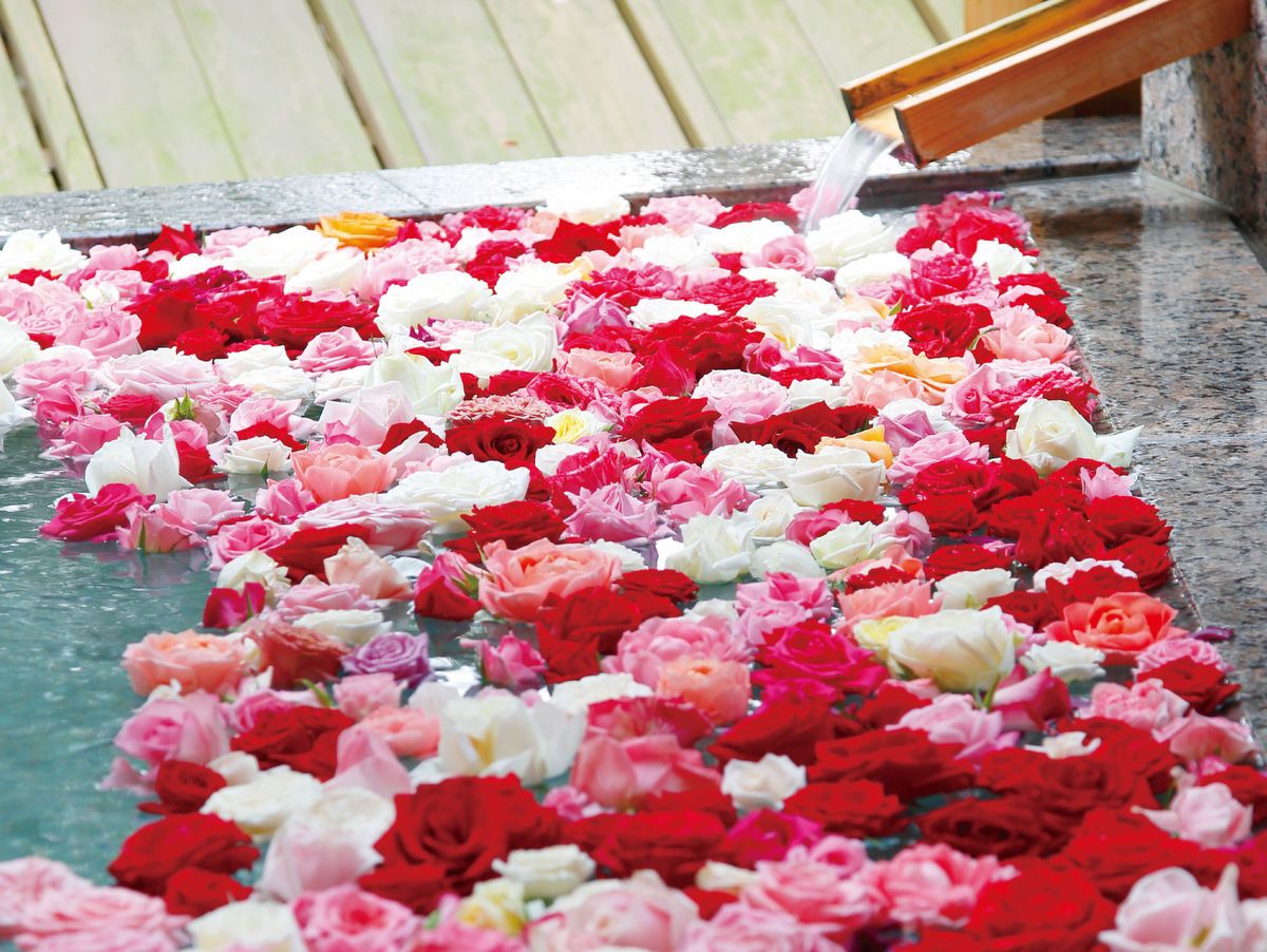 A stone floor with a row of water and flowers.