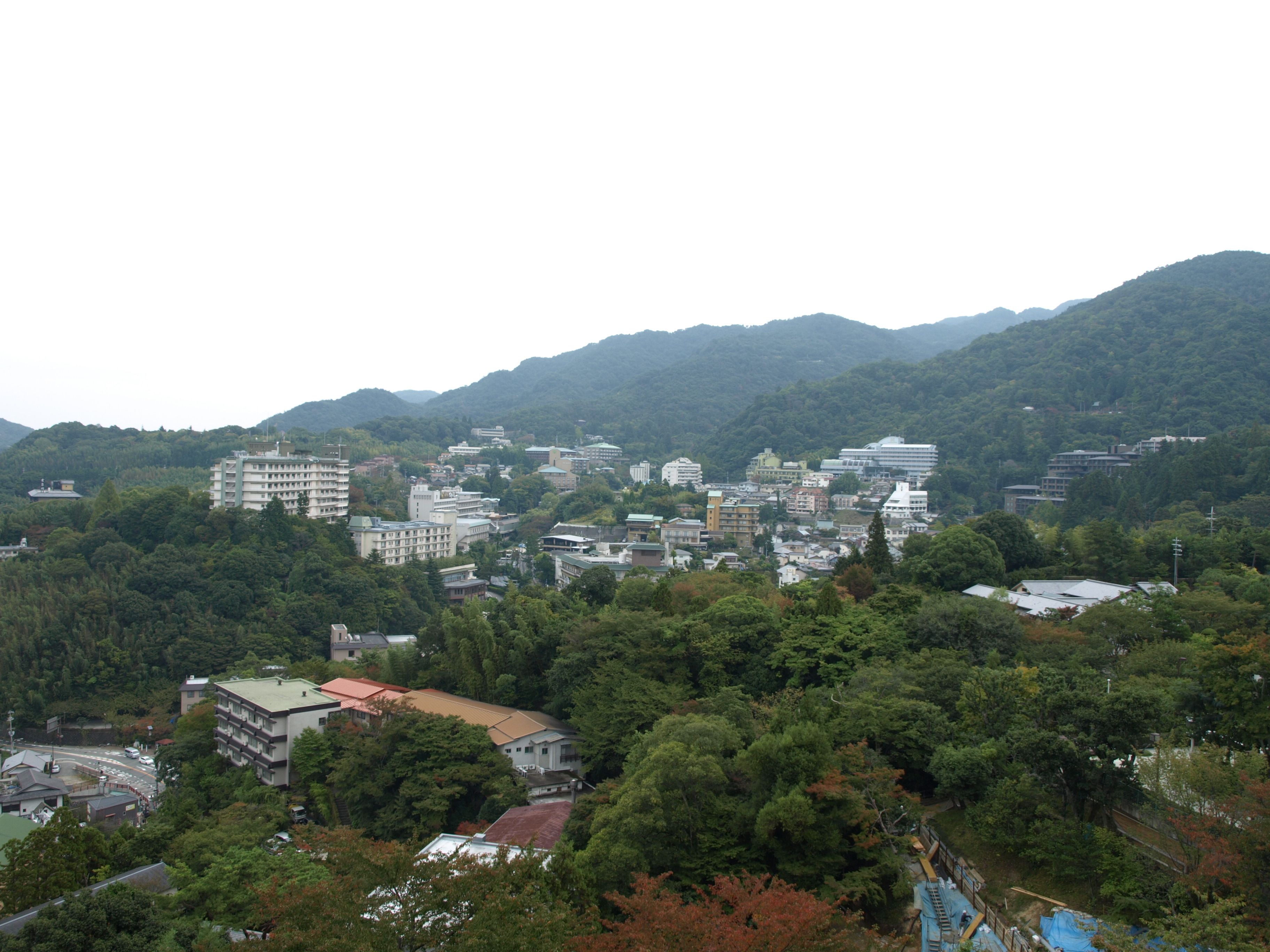 Un pueblo rodeado de bosque denso y colinas.