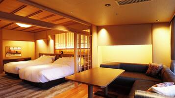 A hotel room with two beds, a sofa, a table, and a large window.