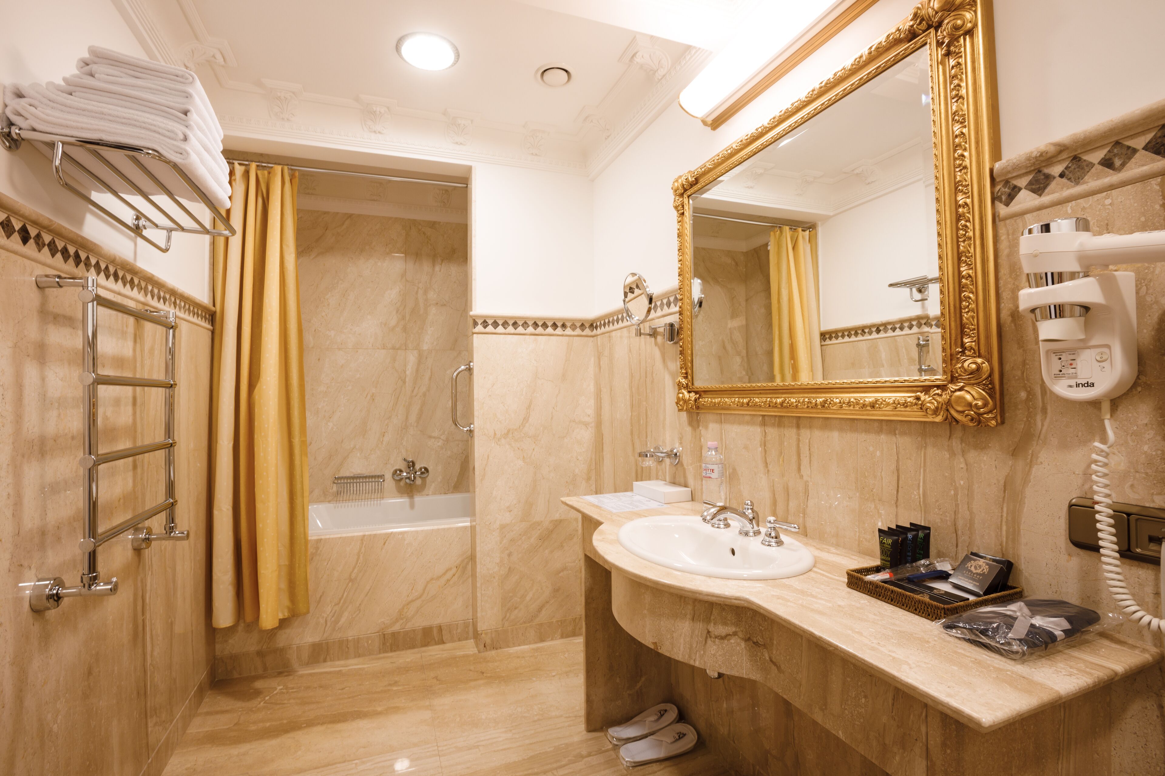 A bathroom with a sink, mirror, and shower.