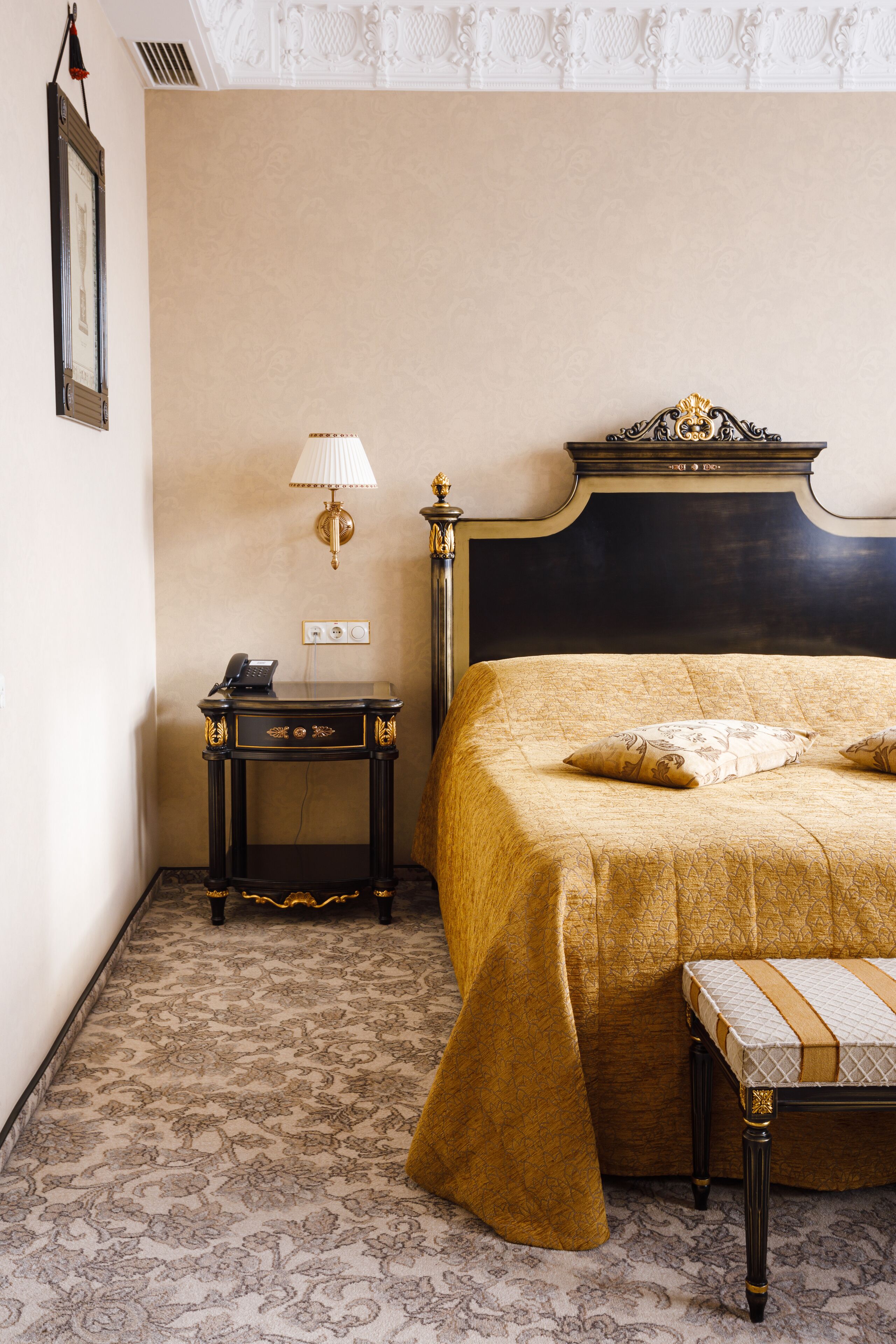 Une chambre d’hôtel avec un lit, une table de chevet, une lampe et une petite table avec un téléphone.