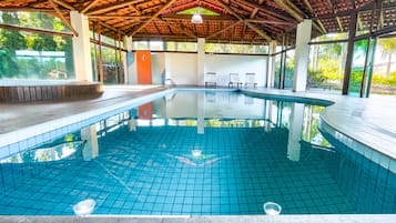 Una piscina techada, sillones reclinables de piscina