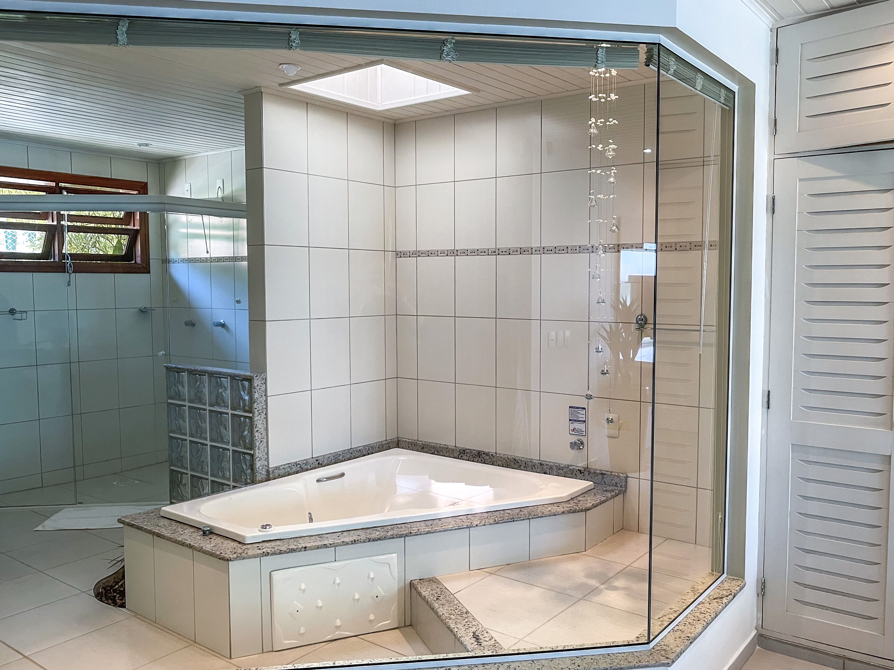 A modern bathroom with a freestanding bathtub, tiled walls, and a glass shower enclosure.
