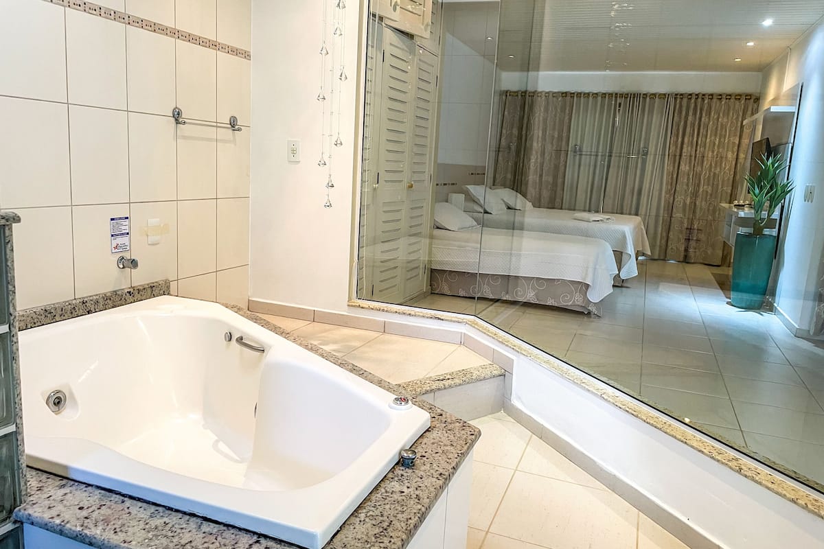 A modern bathroom with a large bathtub, a shower, and a glass-enclosed shower area.