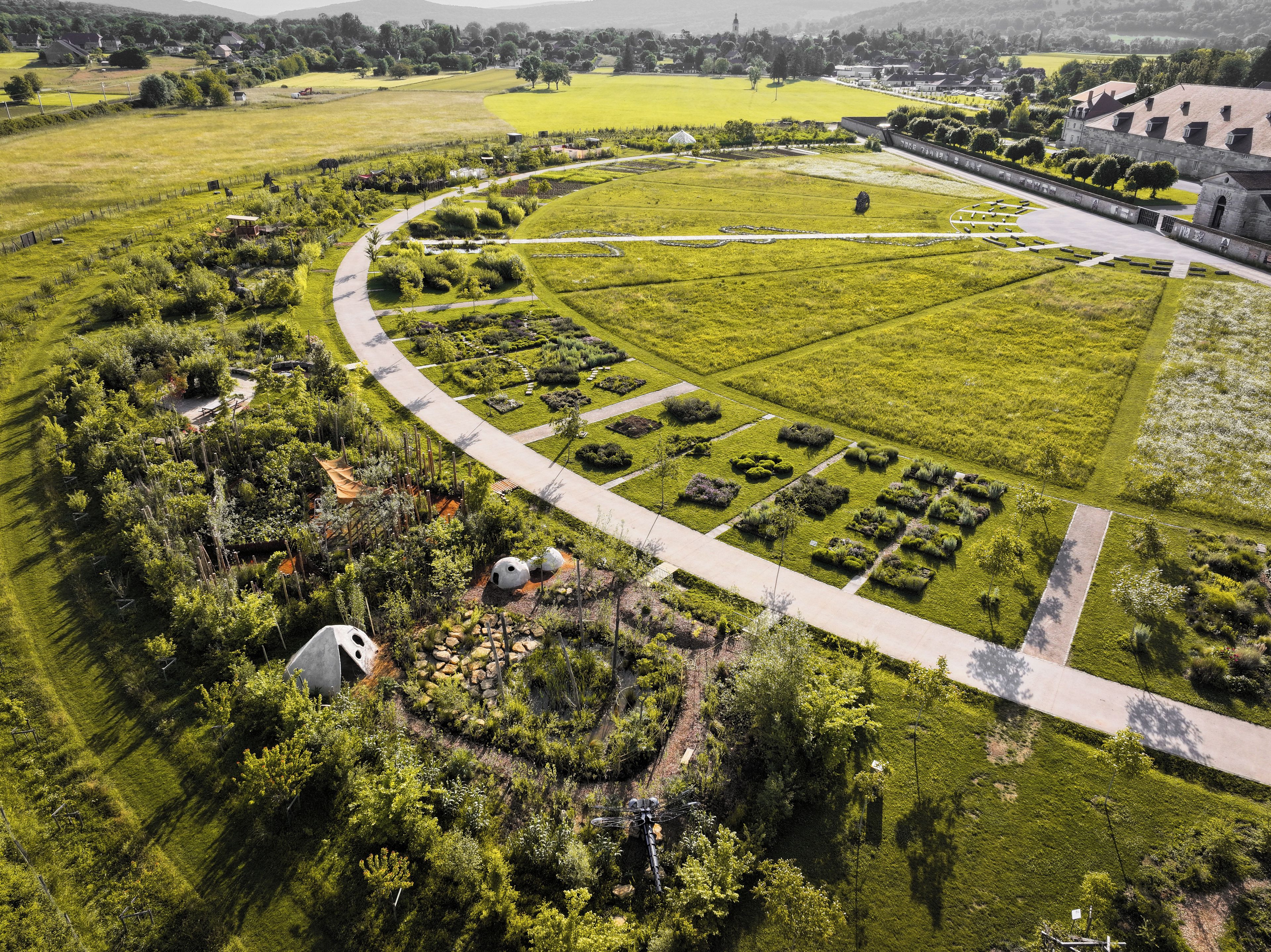 Un jardí paisatjistic amb un camí sinuós, talls de setge ben definits i una zona circular central.