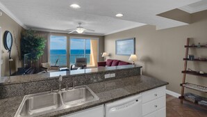 A kitchen with granite countertops, a double sink, and a ceiling fan.