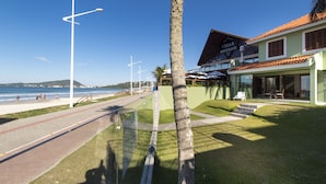 A coastal view with a paved walkway, palm trees, and a building labeled 'Cesar Restaurante'.