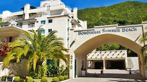 A hotel entrance with a sign reading "Bombinhas Summer Beach" and the number 270. - Aluguel Apartamento 1 quarto Summer Beach 076A (Bombinhas)