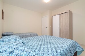Een slaapkamer met een bed, een kledingkast en een deur.
