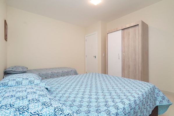 A bedroom with a bed, a wardrobe, and a door.