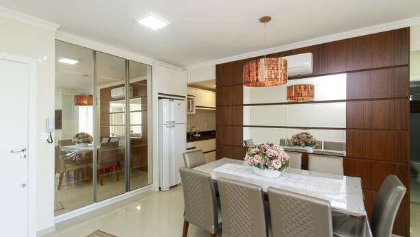 A modern kitchen with a refrigerator, microwave, and wooden cabinets.