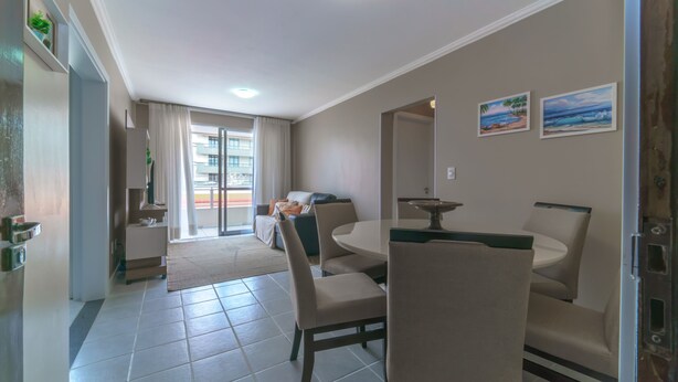 Una habitación de hotel moderna con comedor, sofá y balcón con vistas.