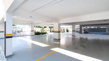 Um amplo parque de estacionamento coberto, com marcações nítidas, pilares e um ambiente limpo e bem iluminado.