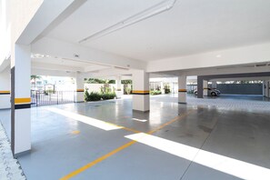 Un amplio estacionamiento interior con señalización clara, pilares y un ambiente limpio e iluminado.