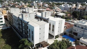 Un edifici modern amb diversos pisos, terrasses planes i una combinació d'espais residencials i comercials.