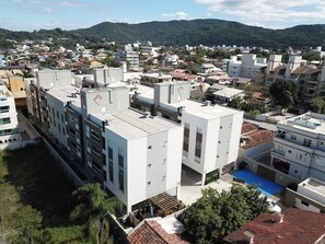Un bâtiment moderne à plusieurs étages, doté de toits plats et comprenant des espaces à usage résidentiel et commercial.