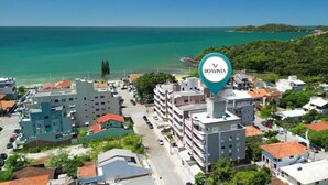 Une ville côtière où se côtoient des bâtiments résidentiels et commerciaux, offrant une vue dégagée sur la mer, et arborant un logo Boavista bien visible sur une icône bleue en forme d’épingle.