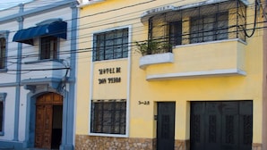 A yellow building with a sign reading "Hotel de Don Pedro" and a stone base. - Hotel de Don Pedro (Guatemala City)