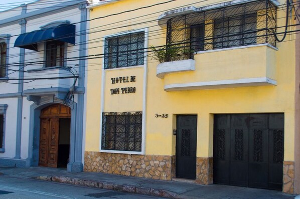 A yellow building with a sign reading "Hotel de Don Pedro" and a stone base. - Hotel de Don Pedro (Guatemala City)