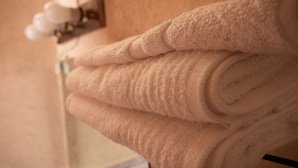 A stack of beige towels on a metal towel rack. - Hotel de Don Pedro (Guatemala City)